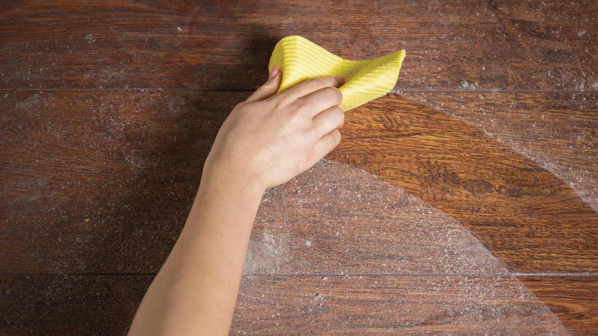 Dust being wiped from a wooden surface for Lindstrom